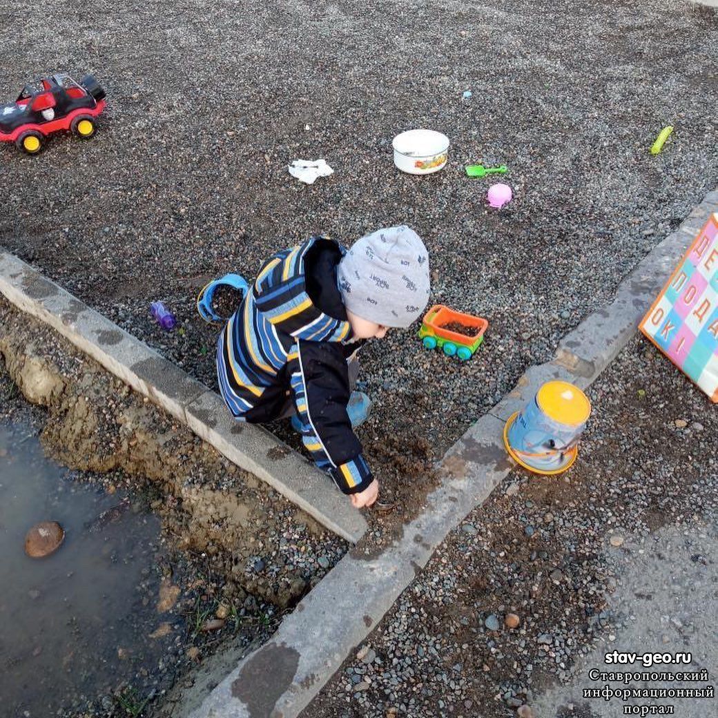 Дети в жилом районе Гармония, по улице К. Симонова и С. Есенина вынуждены играть в лужах и с камнями